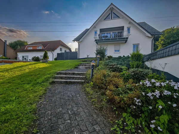 Außenansicht des Hauses der Ferienwohnung in Sundern-Enkhausen mit Balkon und Gartenweg
